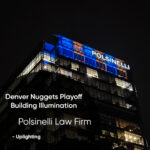 Night shot of a glass office building illuminated in blue with 'POLSINELLI' signage on top; overlay text promotes Denver Nuggets Playoff Building Illumination for Polsinelli Law Firm.