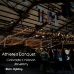 Banquet hall scene with string lights and flags; overlay text reads 'Athlete's Banquet' and 'Colorado Christian University' (Bistro Lighting).